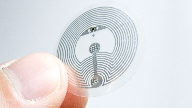 An NTAG 424 DNA NFC tag held between fingers